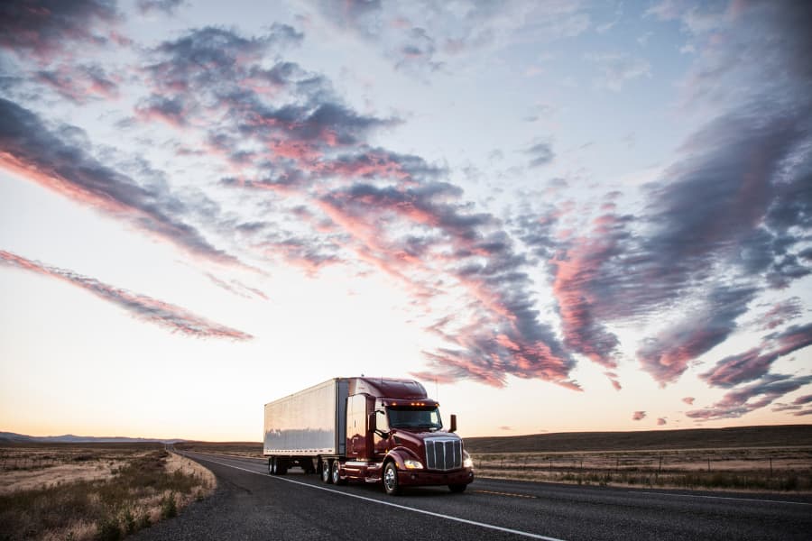 Semi-truck on highway at sunset