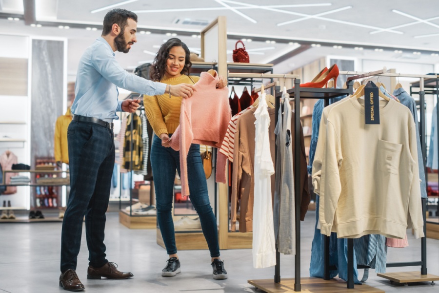 Young woman shopping in a store being helped by an employee