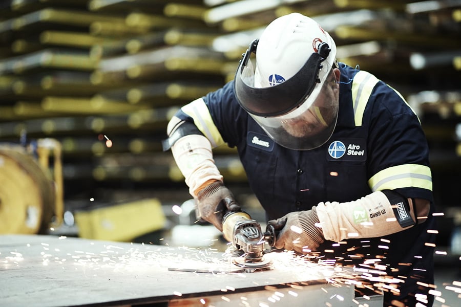 Engineer angle grinding a steel sheet