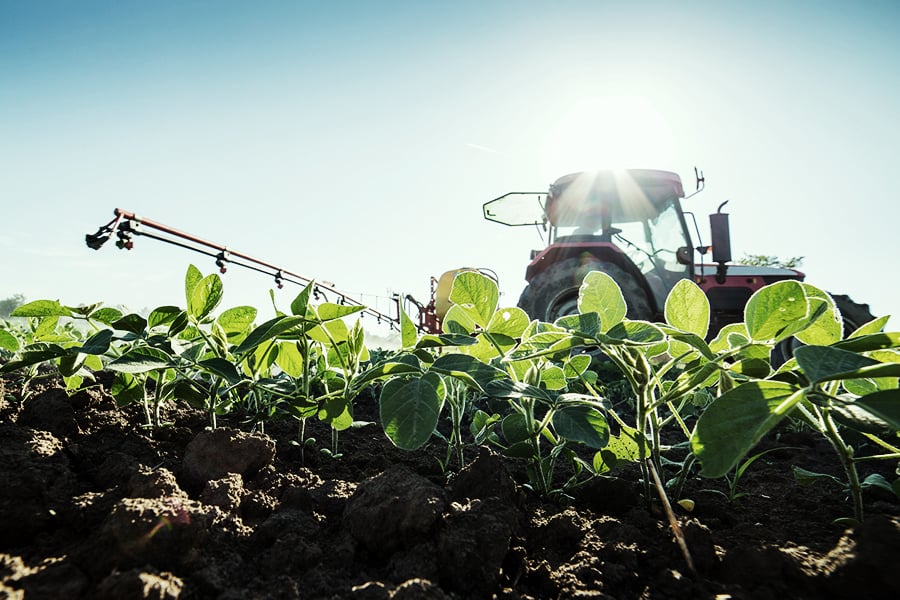 Tractor spraying a field with agrichemicals