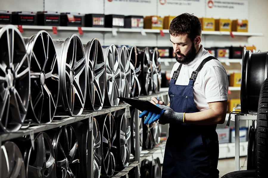 Auto parts store owner checking his inventory of wheels